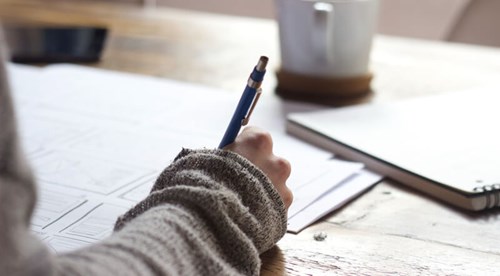 A woman sitting at a desk completing a tax return.